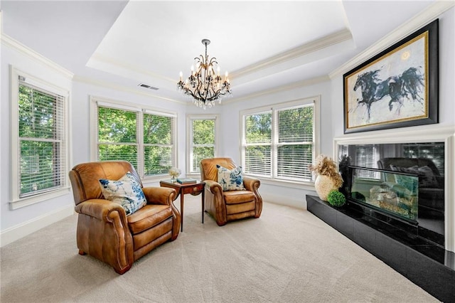 living area with crown molding, a chandelier, a raised ceiling, carpet floors, and baseboards