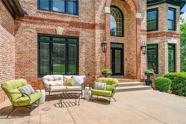 doorway to property featuring brick siding and outdoor lounge area