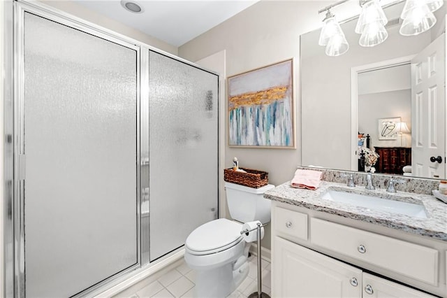 ensuite bathroom featuring tile patterned flooring, a shower stall, toilet, and vanity