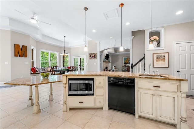 kitchen with dishwasher, cream cabinetry, stainless steel microwave, a sink, and recessed lighting