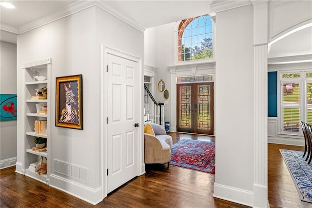 foyer with dark wood-type flooring, stairway, ornamental molding, and baseboards