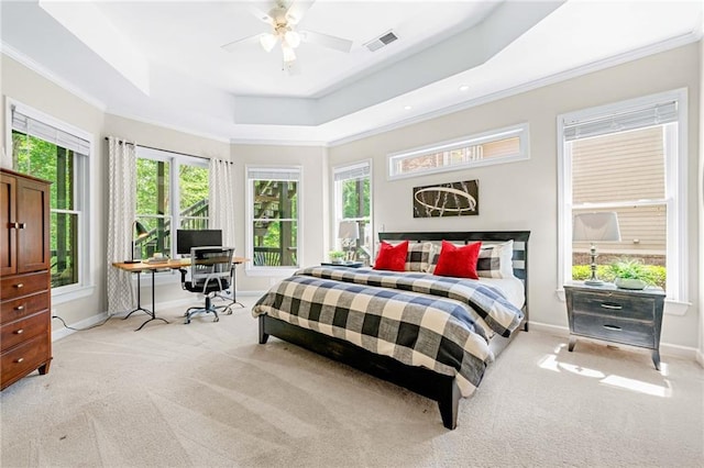 bedroom with light colored carpet, baseboards, an office area, crown molding, and a tray ceiling