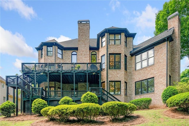 rear view of property with a chimney, stairs, brick siding, and a wooden deck