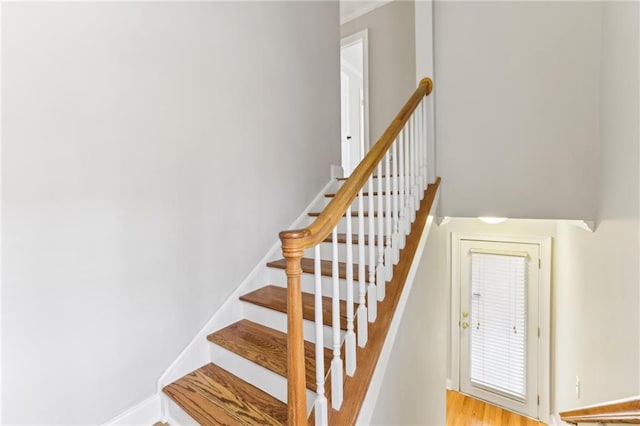 stairs featuring wood finished floors and baseboards