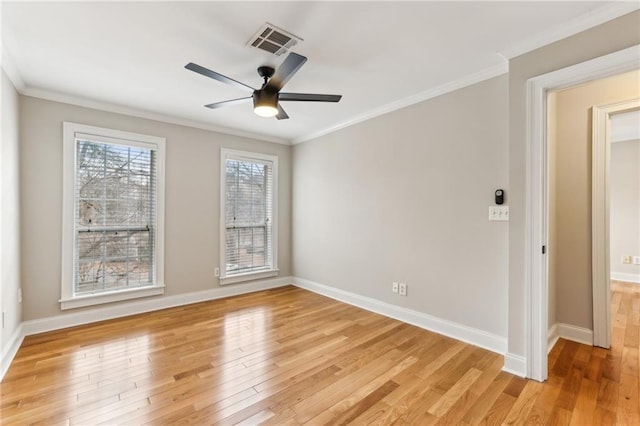 empty room featuring light wood-style floors, visible vents, and ornamental molding