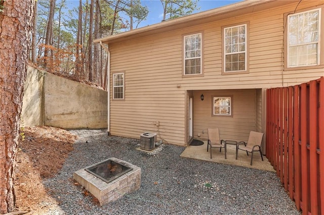 rear view of house with a fire pit, a patio area, and cooling unit