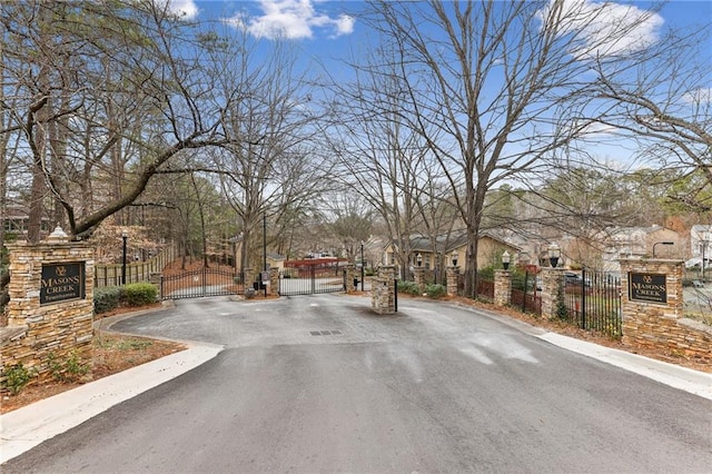 view of road featuring curbs, a gated entry, a residential view, and a gate