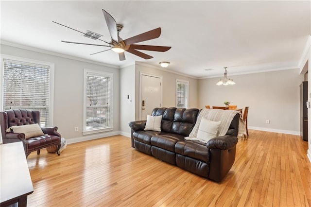 living room featuring ornamental molding, visible vents, light wood-style flooring, and baseboards