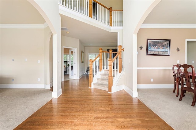 1110 Cureton Dr, Austell, GA 30106 - entrance foyer featuring light carpet, arched walkways, stairs, ornamental molding, and baseboards