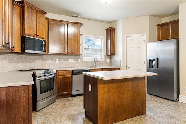 1110 Cureton Dr, Austell, GA 30106 - kitchen featuring stainless steel appliances, decorative backsplash, a center island, a sink, and light countertops