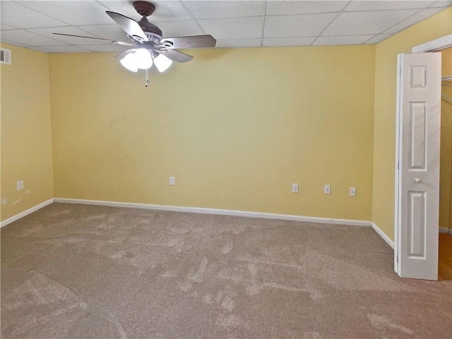 carpeted spare room with a drop ceiling and ceiling fan