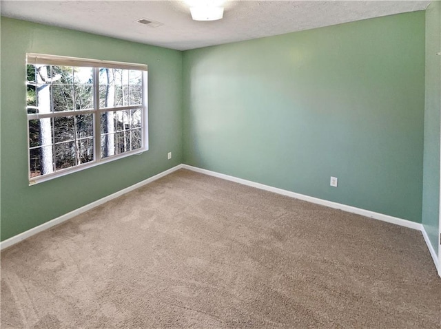 carpeted empty room with a textured ceiling