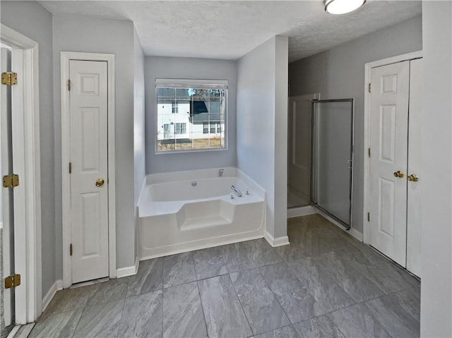 bathroom with separate shower and tub and a textured ceiling