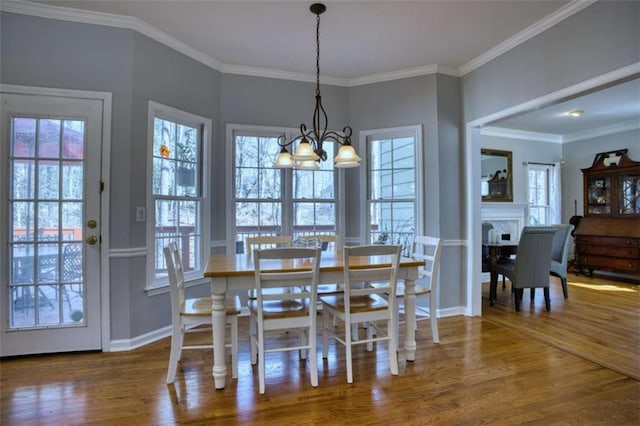 9600 Poplar Ct, Douglasville, GA 30135 - dining room featuring a chandelier, wood finished floors, baseboards, crown molding, and a fireplace