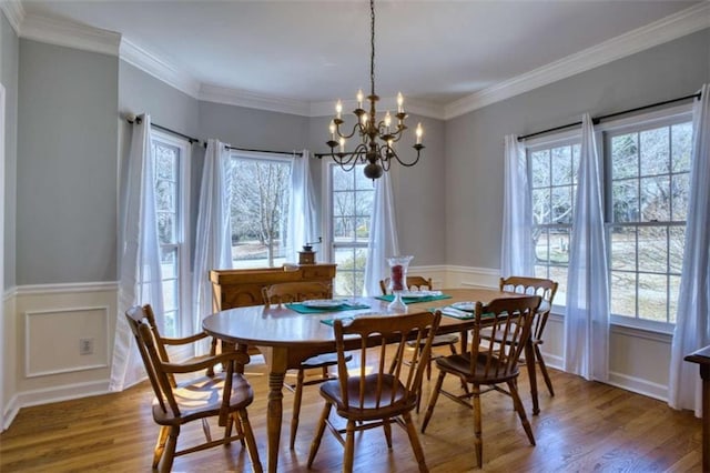 9600 Poplar Ct, Douglasville, GA 30135 - dining area featuring wood finished floors, a chandelier, a decorative wall, a wainscoted wall, and ornamental molding