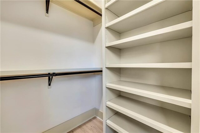 walk in closet with light wood-type flooring