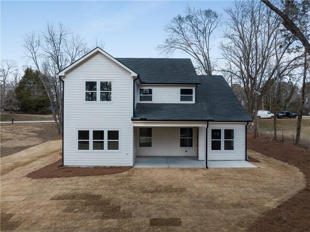 back of house with a patio and a lawn
