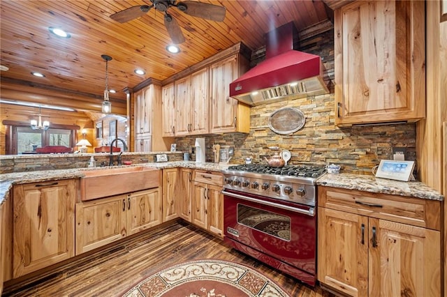 kitchen featuring light stone countertops, luxury stove, custom exhaust hood, and decorative light fixtures