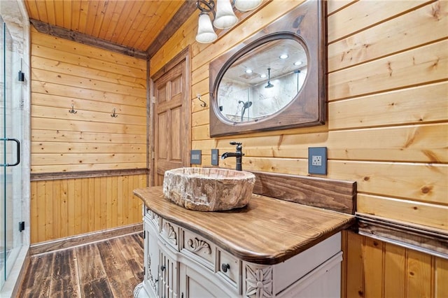 bathroom with vanity, wood ceiling, wooden walls, and hardwood / wood-style flooring