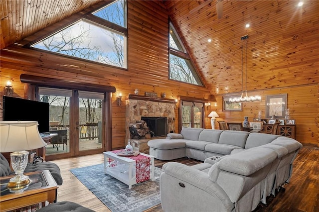 living room with hardwood / wood-style floors, a notable chandelier, and wooden walls