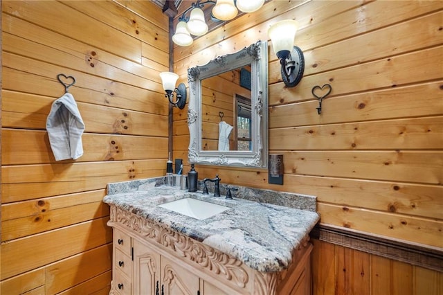 bathroom featuring vanity and wooden walls