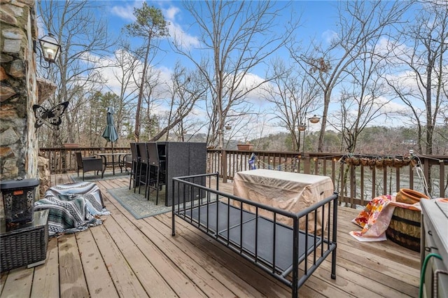 wooden deck featuring a water view, an outdoor hangout area, and an outdoor bar