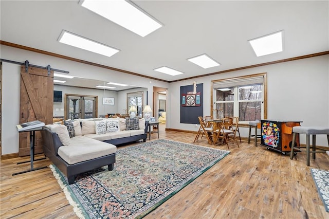 living room featuring hardwood / wood-style flooring, a barn door, and crown molding