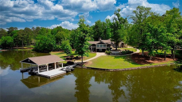 dock area featuring boat lift, a water view, and a yard