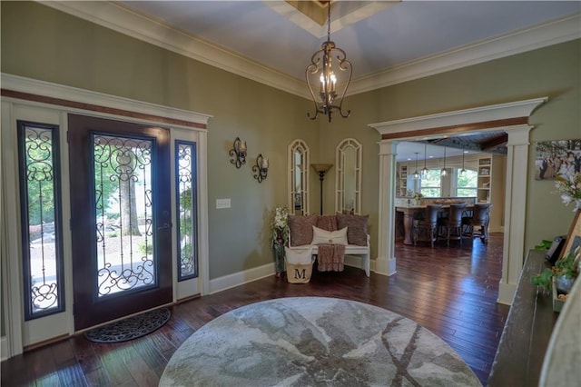 foyer with crown molding, a notable chandelier, baseboards, ornate columns, and hardwood / wood-style flooring