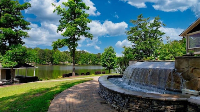 view of community with a lawn and a water view