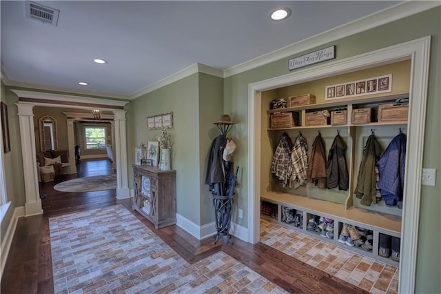 mudroom with crown molding, visible vents, decorative columns, wood finished floors, and baseboards