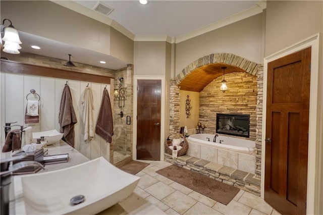 bathroom featuring a garden tub, visible vents, ornamental molding, a sink, and a stall shower