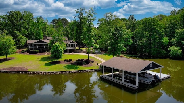 view of dock featuring a lawn, boat lift, and a water view