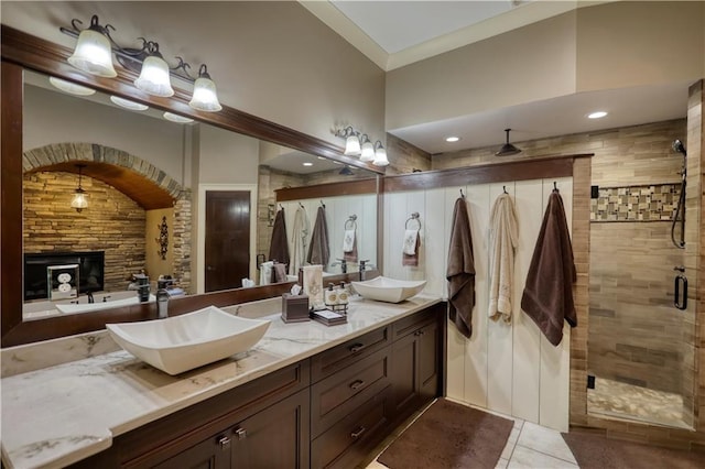 bathroom with double vanity, a shower stall, a sink, and tile patterned flooring