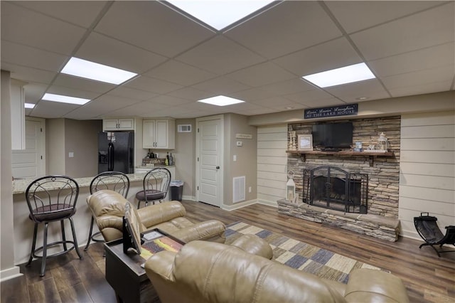 living room with baseboards, a fireplace, dark wood-style flooring, and a paneled ceiling