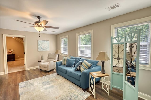 living room featuring baseboards, ceiling fan, visible vents, and wood finished floors