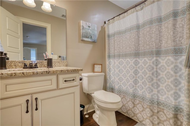 full bathroom featuring visible vents, curtained shower, wood finished floors, vanity, and toilet