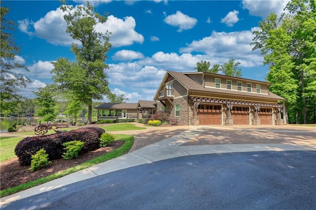 view of front of property with a garage, stone siding, and concrete driveway
