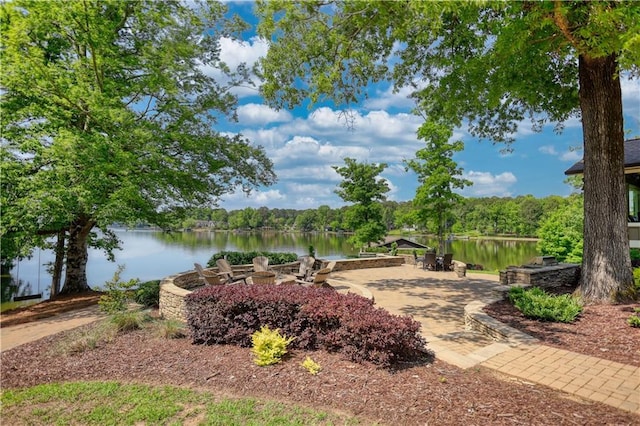 surrounding community with a water view and an outdoor fire pit