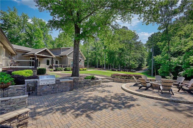 view of patio with a fire pit, exterior kitchen, and grilling area