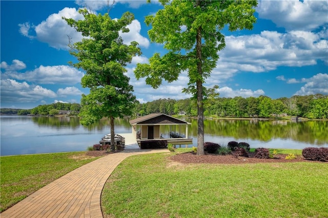 dock area featuring a water view, a yard, and a wooded view