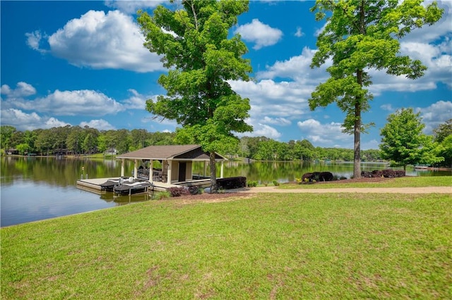 view of dock featuring a yard, a water view, and a wooded view