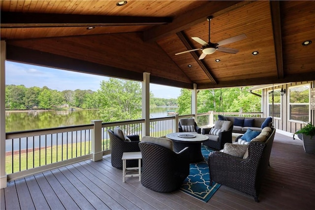 wooden deck with a water view, ceiling fan, and outdoor lounge area