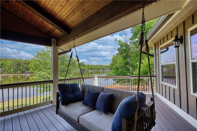 wooden terrace with a water view and an outdoor living space