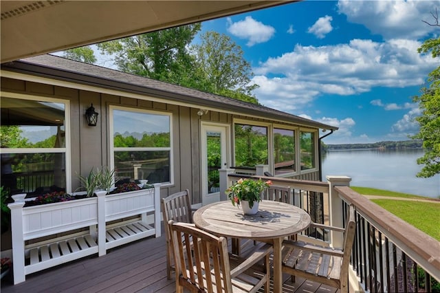 wooden terrace featuring a water view and outdoor dining space