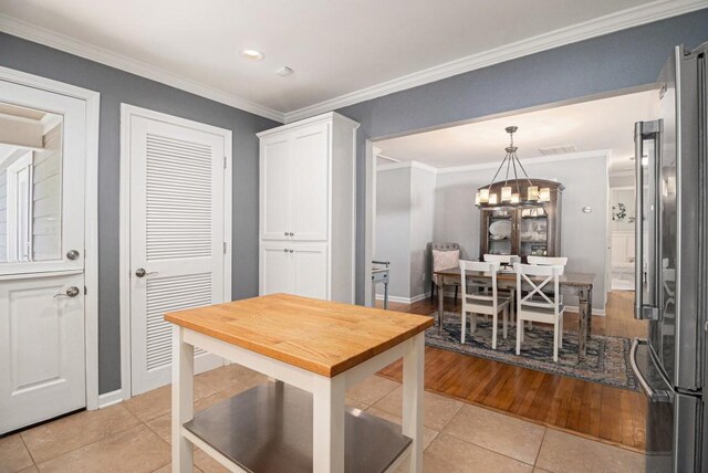 dining space featuring crown molding, light tile patterned floors, baseboards, a chandelier, and recessed lighting