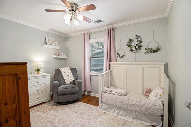 sitting room featuring ceiling fan, visible vents, ornamental molding, and wood finished floors