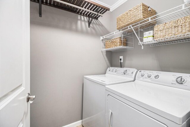 clothes washing area featuring baseboards, laundry area, and washing machine and clothes dryer