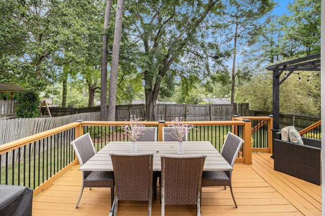 deck featuring a fenced backyard and outdoor dining space