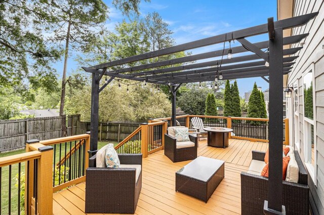 wooden terrace featuring a fenced backyard, a pergola, and an outdoor fire pit